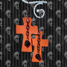 Load image into Gallery viewer, Double sided orange faux leather flared cross earrings with black howlite skull on black chain accent 
